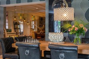 a dining room with a table and chairs and a chandelier at Boutique Hotel Slenaker Vallei - Buitengewoongenieten in Slenaken