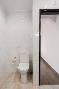 een wit toilet in een badkamer met marmeren muren bij ALTIDO Cosy studio wtih parking and garden 