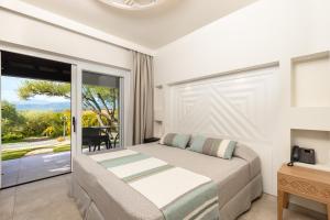 a bedroom with a bed and a large window at Hotel Club Saraceno - Bovis Hotels in Àrbatax
