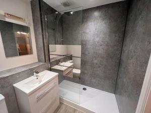 uma casa de banho com um lavatório e um chuveiro com um espelho. em Lincoln View. Sleeps 6. Balcony. Self check-in. em Lincolnshire
