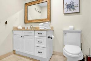 Un baño con un inodoro blanco y un espejo. en Lux 2BR Condo in Ocean Reserve with Pools and Tennis Courts, en Miami Beach 12 fotos más