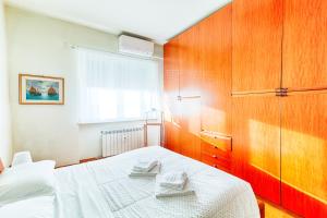 a bedroom with a bed with two towels on it at Exclusive Apartment a 10 minuti da Teatro Rossetti in Trieste