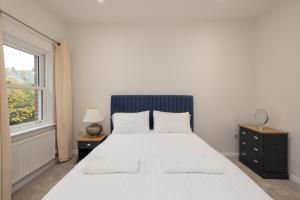 達拉謨的住宿－The Sidings，卧室设有一张白色大床和一扇窗户。