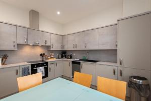 a kitchen with white cabinets and a table and chairs at The Sidings in Durham