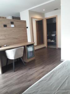 a room with a desk and a tv on a wooden floor at Garni Al Silvestri Vei in Livigno