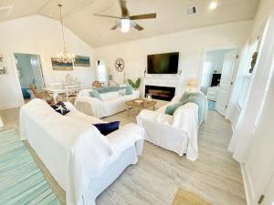 ein Wohnzimmer mit weißen Möbeln und einem Kamin in der Unterkunft Reader's Retreat home in Crystal Beach