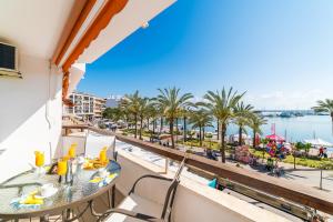 ポルト・ダルクディアにあるIdeal Property Mallorca - Mimosaのテーブルと椅子付きのバルコニーから水辺の景色を望めます。