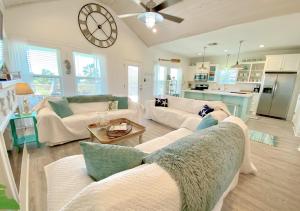 ein Wohnzimmer mit zwei Sofas und einer Uhr an der Wand in der Unterkunft Reader's Retreat home in Crystal Beach