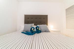 two blue rubber swans sitting on a bed at Ideal Property Mallorca - Mimosa in Port d'Alcudia