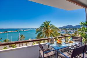 een tafel op een balkon met uitzicht op de oceaan bij Ideal Property Mallorca - Enjoy in Port d'Alcudia