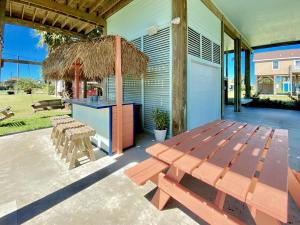 eine Terrasse mit einem Picknicktisch und einem Grill in der Unterkunft Reader's Retreat home in Crystal Beach