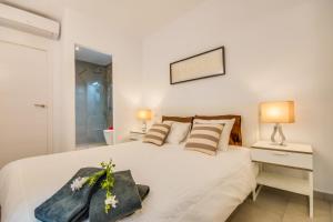 een slaapkamer met een groot wit bed en een spiegel bij Ideal Property Mallorca - Enjoy in Port d'Alcudia