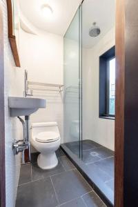 e bagno con servizi igienici, lavandino e doccia. di E10-2 Designer East Village Townhouse 1BR W D a New York