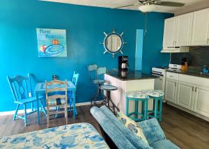 cocina con paredes azules y sillas azules en Searenity, Waterside studio in the heart of Treasure Island, walk to beach en St Pete Beach