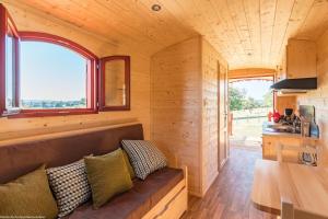 a living room of a tiny house with a couch at Roulotte La Comtoise 