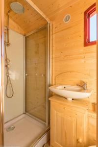 y baño de madera con ducha y lavamanos. en Roulotte La Comtoise, 