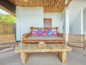 uma cama num quarto com uma mesa e cadeiras em Villa Mimpi Tamarind em Amed