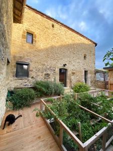 un gato negro sentado frente a un edificio en Gîte : La vieille bâtisse., en La Baume-Cornillane