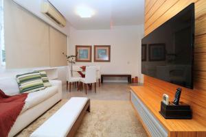 sala de estar con sofá blanco y TV de pantalla plana grande en Incrível 2 quartos no coração de Ipanema D054, en Río de Janeiro