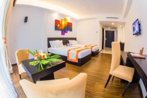 um quarto de hotel com uma cama, uma mesa e cadeiras em The Covanro Airport Hotel - Katunayake em Gampaha