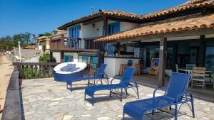 a patio with chairs and a table and a building at Vila Bela-Emília in Búzios