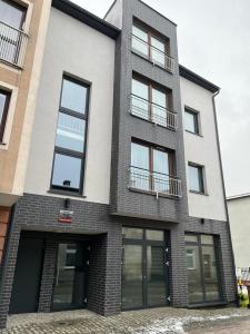 a tall brick building with windows on a street at Kawalerka Wałowa 7 in Wejherowo