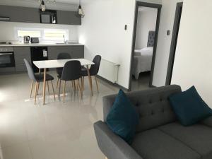 uma sala de estar com um sofá e uma mesa com cadeiras em Apart Fueguina em Porvenir