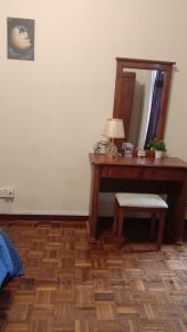 um quarto com uma secretária, um espelho e um banco em D'Mentari - Cozy 3 Rooms Apartment em Porto Dickson