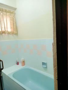 uma banheira branca na casa de banho com uma janela em D'Mentari - Cozy 3 Rooms Apartment em Porto Dickson