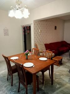 uma mesa de madeira e cadeiras numa sala de estar em D'Mentari - Cozy 3 Rooms Apartment em Porto Dickson