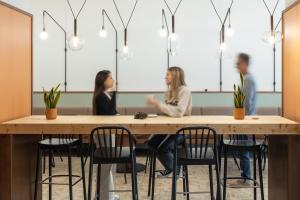 a group of people sitting at a table in a room at Hotel Orangine in Hospitalet de Llobregat