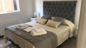 een slaapkamer met een groot bed en handdoeken bij Apart Fueguina in Porvenir