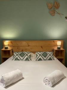 a bedroom with a bed with two towels on it at La Maison des lilas, 5 mn de Beauval in Saint-Aignan