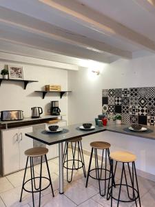 聖艾尼昂的住宿－La Maison des lilas, 5 mn de Beauval，厨房配有3张吧台凳和1个柜台