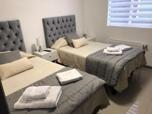 um quarto com duas camas com toalhas nos assentos em Apart Fueguina em Porvenir