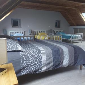 a bedroom with a bed with a blue and white comforter at L'Escapade à la Banut in Jallandrieu