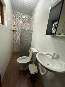 a bathroom with a toilet and a sink at Pousada Belas Praia - Ribanceira in Imbituba