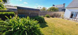 a yard with a retaining wall and a fence at Gîtes Neige d'écume in Ouessant