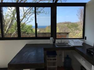 eine Küche mit einem Waschbecken und zwei großen Fenstern in der Unterkunft Bungalow Doble Con Vista parcial al Mar, Cocina Completa in Cuatunalco