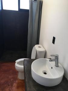 ein Badezimmer mit einem weißen WC und einem Waschbecken in der Unterkunft Bungalow Doble Con Vista parcial al Mar, Cocina Completa in Cuatunalco