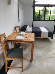 einen Tisch mit 2 Stühlen und ein Bett in einem Zimmer in der Unterkunft Bungalow Doble Con Vista parcial al Mar, Cocina Completa in Cuatunalco