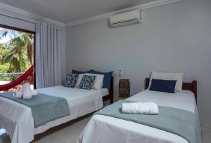 two beds in a room with a window at Casa de Praia Maragogi in Maragogi