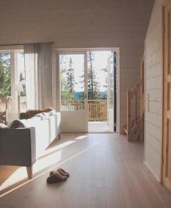 a living room with a white couch and a sliding glass door at Tännäskröket in Tännäs