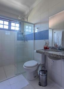 a bathroom with a toilet and a shower and a sink at Casa de Praia Maragogi in Maragogi