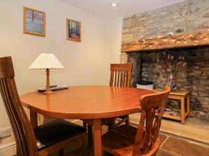 a wooden table in a room with a fireplace at Beech Cottage in Stroud