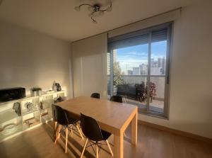 uma sala de jantar com uma mesa e uma grande janela em Beach & Culture Barcelona Port Forum Penthouse Apartment em Barcelona