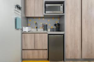 a small kitchen with a sink and a microwave at One Thibault Luxury Apartments in Cape Town