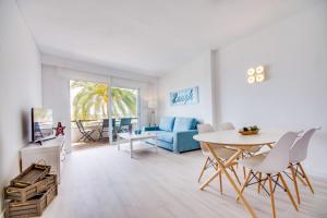 ポルト・ダルクディアにあるIdeal Property Mallorca - Canet Beachのリビングルーム(テーブル、青いソファ付)
