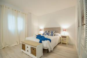 ポルト・ダルクディアにあるIdeal Property Mallorca - Canet Beachの白いベッドルーム(ベッド1台、テーブル付)