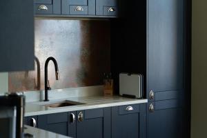 a kitchen with blue cabinets and a sink at Beachfront Bolthole with Luxury, Style and Spectacular Sea Views in Herne Bay